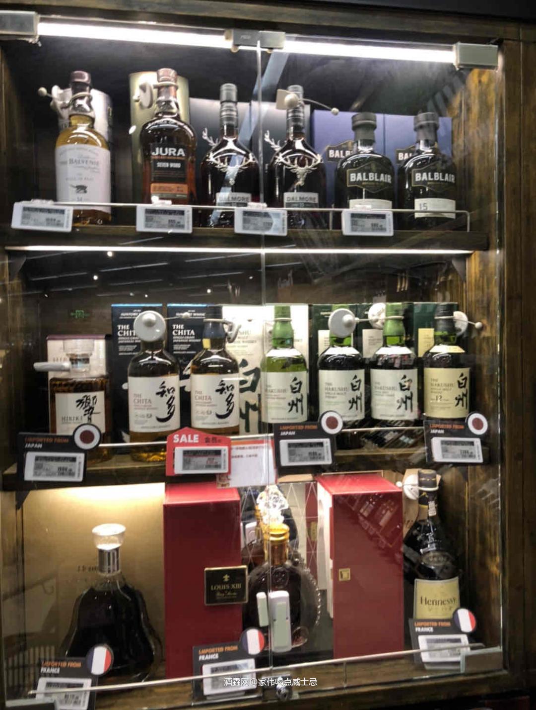 各种各样的酒摆放整齐就是一道漂亮的风景线咔嚓拍照